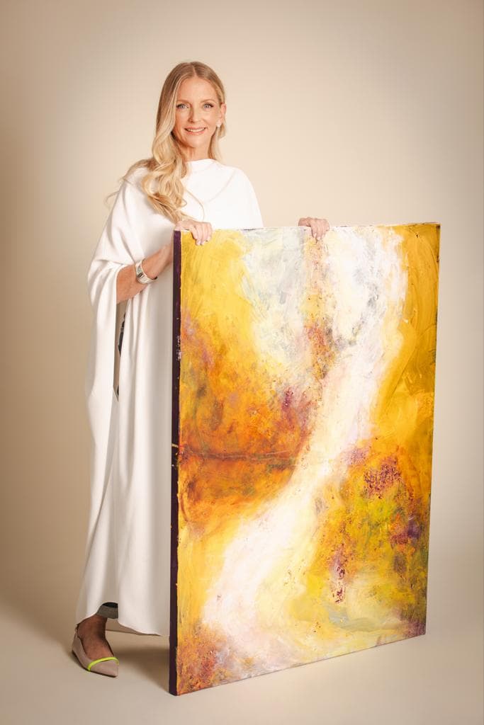 Bernice Abadi holding one of her paintings